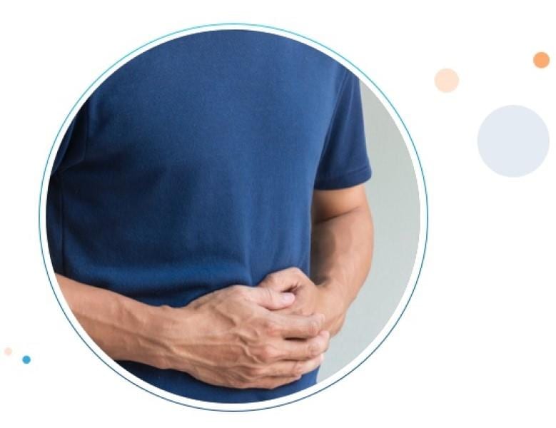 Un hombre presionando sus manos en el estómago por el dolor abdominal.