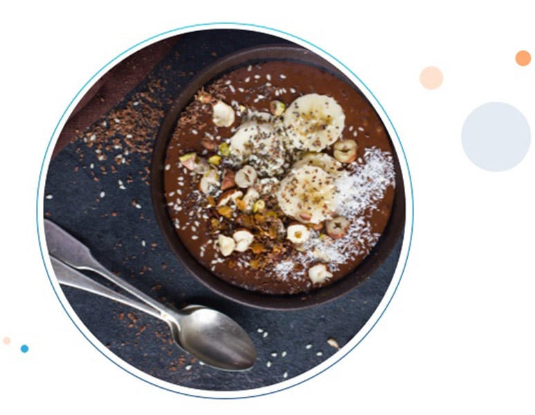 Un tazón de smoothie de chocolate con plátano y nueces, junto a un pequeño tazon de nueces y semillas para la intolerancia al gluten y efectivo contra la acidez.