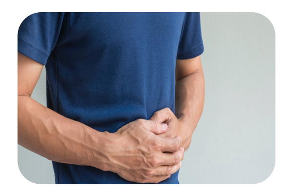 Un hombre presionando sus manos en el estómago por el dolor abdominal.
